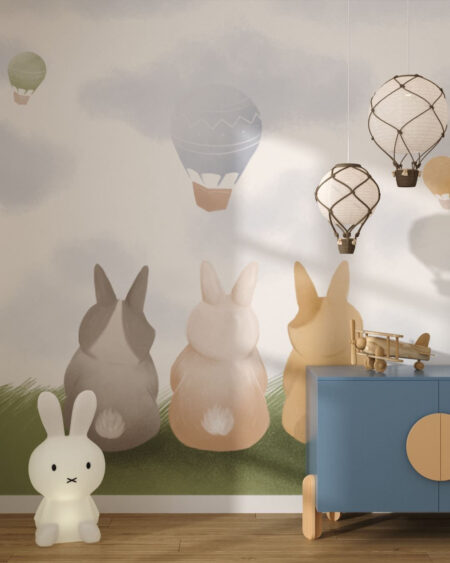 Tapete mit drei Hasen im Gras und fliegenden heißluftballons für ein Kinderzimmer