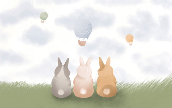 Tapete mit drei Hasen im Gras, die fliegende heißluftballons in den Wolken betrachten